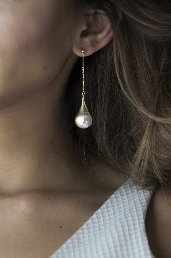 This pair of gold and pearl elegant drop earrings will compliment your bridal look and make you look like you just stepped out of the pages of a fashion magazine. The pearls are artfully held in place by gold shells giving a dainty and feminine look that will take you from the aisle dance floor. Just stunning!